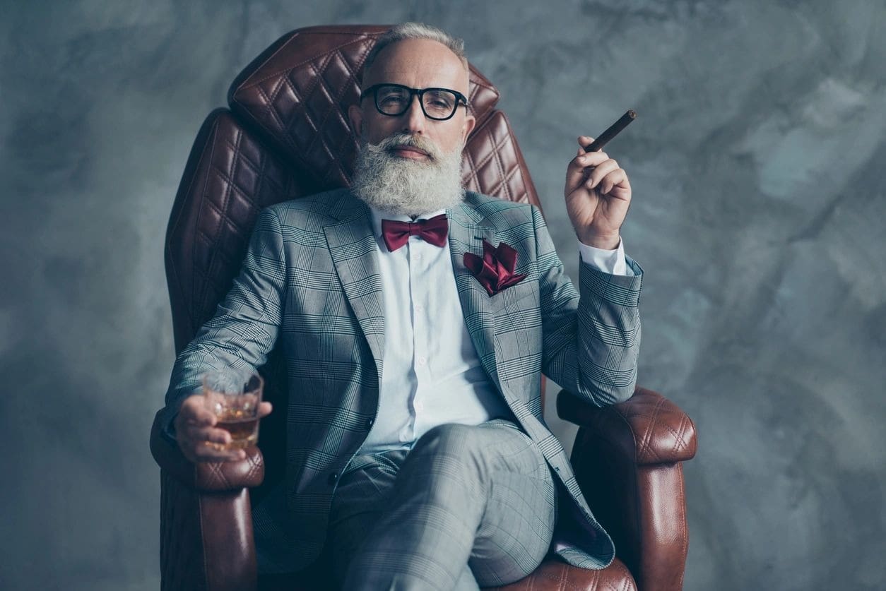 A man sitting in a chair with a cigar.